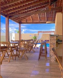 - un ensemble de tables et de chaises sur une terrasse dans l'établissement RECANTO DAS ÁGUAS VILLE, à Santo Amaro