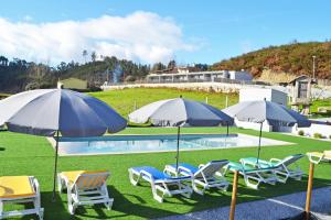 a group of chairs and umbrellas next to a pool at Campo Seco in Vieira do Minho