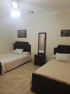 - une chambre avec 2 lits et un miroir mural dans l'établissement Lazorde Bay Apartment, à El Alamein