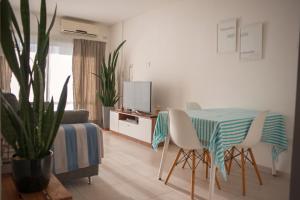 sala de estar con mesa, sillas y TV en Departamento Premium con cochera y piscina en Bahía Blanca