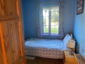 ein kleines Schlafzimmer mit einem Bett und einem Fenster in der Unterkunft 3 Bed town house 10 min from beach in Tramore