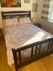 1 cama grande en un dormitorio con suelo de madera en 3 Bed town house 10 min from beach, en Tramore