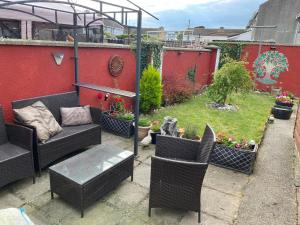 a patio with a couch and chairs and a garden at 3 Bed town house 10 min from beach in Tramore