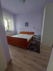 a bedroom with a large bed and a wooden floor at Regina Vendégház Miskolc in Miskolc