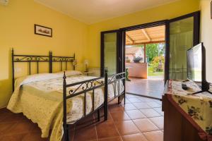 a bedroom with a bed and a sliding glass door at Agriturismo il Laghetto in Grosseto