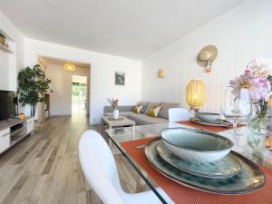 uma sala de estar com uma mesa e cadeiras e um sofá em Comfortable apartment with parking - Antibes Riviera em Antibes