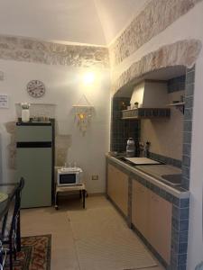een keuken met een wastafel, een koelkast en een fornuis bij Casetta Nobile in Ostuni