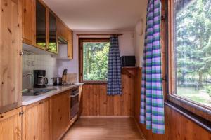 eine Küche mit Holzschränken und einem Fenster in der Unterkunft Chalupa Cidlina in Cidlina