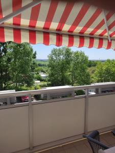 un balcón con una sombrilla roja y blanca en Gästewohnung in Hohenstein-Ernstthal en Hohenstein-Ernstthal