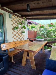 una mesa de picnic de madera en una terraza con plantas en Riviera Zator, en Zator