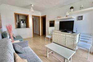 salon z kanapą i telewizorem z płaskim ekranem w obiekcie Buena vista, apartamento en la playa Finestrat w mieście Cala de Finestrat