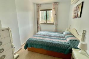mała sypialnia z łóżkiem i oknem w obiekcie Buena vista, apartamento en la playa Finestrat w mieście Cala de Finestrat