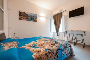 a bedroom with a bed with a blue comforter at LA MANDORLA Luxury Rooms in Caltabellotta