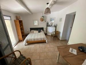 um quarto com uma cama e uma mesa em Le mazet en été - studio en garrigue nimoise em Nîmes