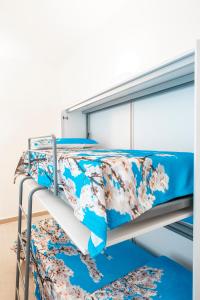 Litera con ropa de cama blanca y azul en LA MANDORLA Luxury Rooms en Caltabellotta