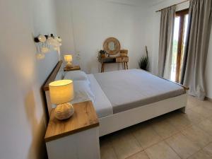 a bedroom with a bed and a table with a lamp at Omikron in Mikro