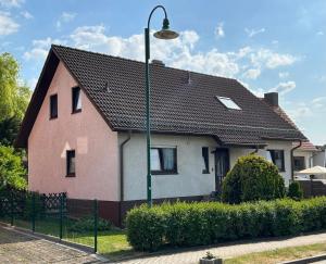 a pink and white house with a street light at Ferienwohnung Familie Putschke in Nohra