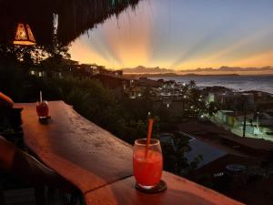 ein Getränk auf einem Tisch mit Meerblick in der Unterkunft Pipa Ubaia Residence 121 in Pipa
