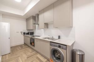 a kitchen with a sink and a washing machine at The Pocklington - The Graduate Suite in Leicester