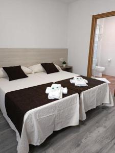 Albergue Miraiso في أرزوا: غرفة نوم بسرير كبير عليها مناشف