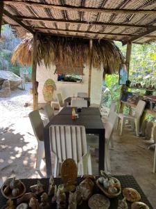 uma mesa de jantar e cadeiras debaixo de um guarda-sol de palha em La Cima Tayrona em Santa Marta