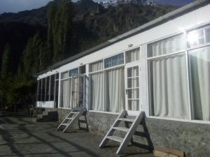 eine Reihe von Fenstern auf einem Gebäude mit Bergen im Hintergrund in der Unterkunft Venus Mountain Resort, Hunza in Hunza