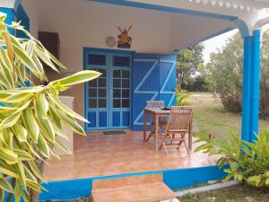 a house with a blue door and a table and chairs at Au Village de Menard in Saint-Louis