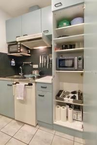 a kitchen with white cabinets and a microwave at Ruhiges Naturparadies für 4 mit Küche Schreibtisch und Boxbett in Wetter