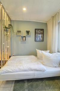 1 dormitorio con 1 cama grande con sábanas y almohadas blancas en Ruhiges Naturparadies für 4 mit Küche Schreibtisch und Boxbett, en Wetter