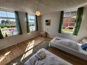 a bedroom with two beds and two windows at City Breakaway in Sønderborg