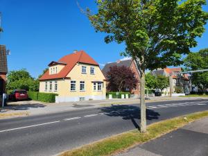 a tree on the side of a street with a house at City Breakaway in Sønderborg
