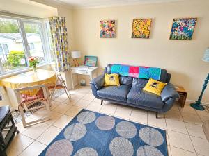 a living room with a couch and a table at Dart Haven - cheerful holiday bungalow in Galmpton in Galmpton-on-the-Dart