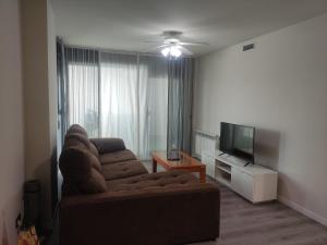 a living room with a couch and a flat screen tv at WANDA Patrimonio parking gratis LICENCIA TURISTICA VT-13975 in Alcalá de Henares