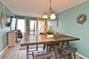 a dining room with a table and some chairs at Sweet Caroline Remodeled with Partial Ocean View and Oceanfront Pool in Myrtle Beach