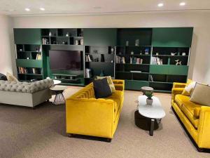 una sala de estar con muebles amarillos y paredes verdes. en Caulfield Village Apartment en Melbourne