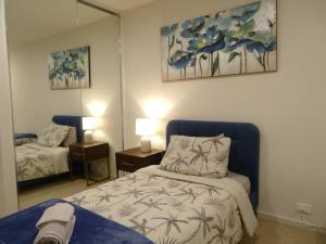 1 dormitorio con cama y espejo en Caulfield Village Apartment en Melbourne