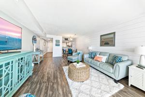 a living room with a couch and a tv at Edgewater West 63 in Gulf Shores