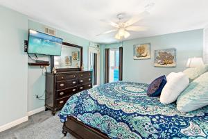 a bedroom with a bed with a ceiling fan and a tv at Edgewater West 63 in Gulf Shores +32 photos
