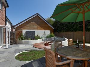 a patio with a table and a green umbrella at Pass the Keys Beautiful Family Home Sleeps 6 in Emsworth