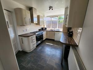 a kitchen with white appliances and a tile floor at Solihull Shared House in Birmingham