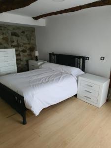 ein Schlafzimmer mit einem großen Bett mit zwei Nachttischen in der Unterkunft Casa Manuel in Toldaos