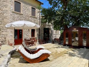 a patio with a table and an umbrella at La quercia B&B in Abbateggio