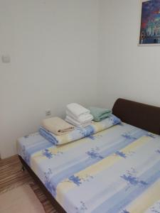a bed with blue and white sheets and towels on it at APARTMAN BUKULJA 2 in Arandelovac +36 photos