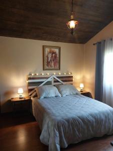 a bedroom with a large bed with lights on it at Ruta Del Aguila alojamiento turístico de calidad in Santa María de la Alameda