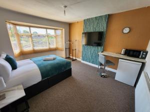 a hotel room with a large bed and a desk at Solihull Shared House in Birmingham