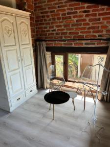 Cette chambre dispose de deux chaises, d'une table et d'un mur en briques. dans l'établissement Apartamentos La Cabaña del Cerro Alto, à Beceña