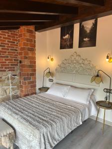 - une chambre avec un grand lit dans un mur en briques dans l'établissement Apartamentos La Cabaña del Cerro Alto, à Beceña