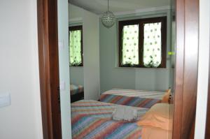 een slaapkamer met 2 bedden en 2 ramen bij La terrazza da Barbara in Torrita di Siena