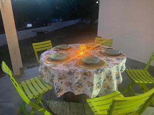 uma mesa com cadeiras amarelas e uma mesa com uma toalha de mesa em Domu Istella em SantʼAnna Arresi