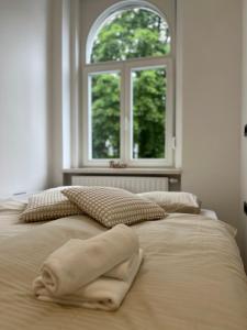 ein weißes Bett mit einem Fenster in einem Schlafzimmer in der Unterkunft City Apartment Chiara in Maribor